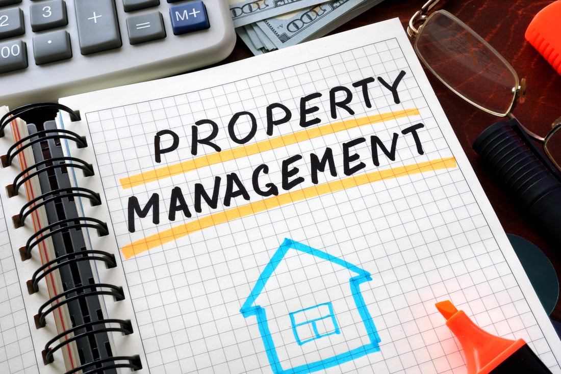 Notebook with property management  sign on a table.